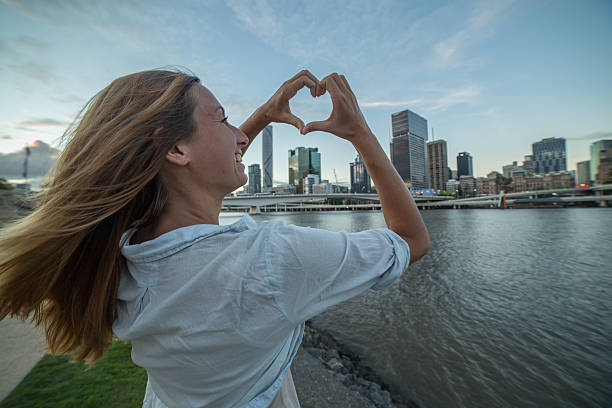 istock Caucasian female makes heart shape finger frame to Brisbane 589939438