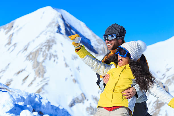 istock Cheerful young couple making selfie on snow mountain 589939838
