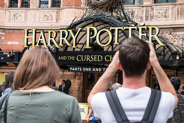 Harry Potter and the Cursed Child in Palace Theatre, London London, England - August 13, 2016: Harry Potter and the Cursed Child showing at the Palace Theatre in the West End. A young Caucasian male is taking a photo of the outside of the theatre. inner london stock pictures, royalty-free photos & images