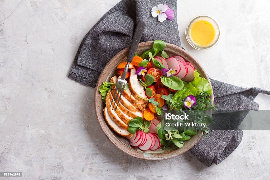 Spring salad with vegetables, chicken breast and edible flowe Spring salad with vegetables, chicken breast and edible flower for healthy dinner, selective focus Food Stock Photo