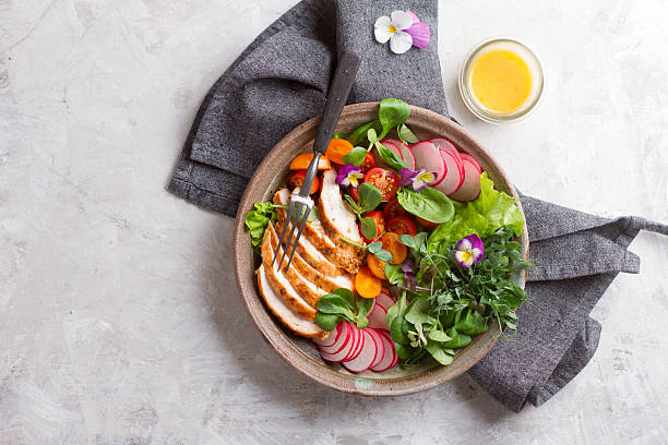 Spring salad with vegetables, chicken breast and edible flowe Spring salad with vegetables, chicken breast and edible flower for healthy dinner, selective focus green pea photos stock pictures, royalty-free photos & images
