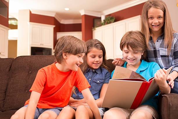 istock Children at home reading books together. 589944894