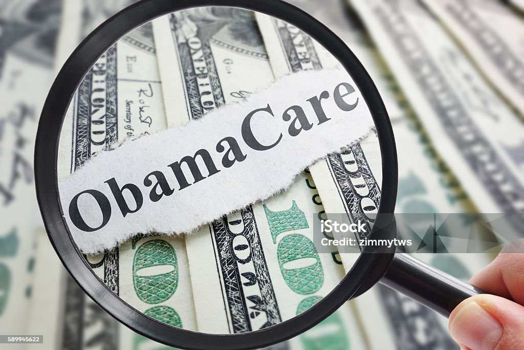 Obamacare and magnifying glass Obamacare newspaper headline on cash with magnifying glass Patient Protection and Affordable Care Act Stock Photo