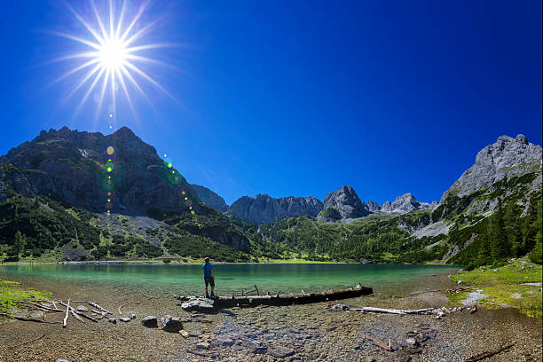 Hiker at alpin Lake at sunny day - Seebensee Tirol Hiker ist looking at alping Lake at sunny day - Seebensee in Tirol ehrwald stock pictures, royalty-free photos & images