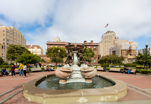 San Francisco, CA, USA - July 15, 2016: Fairment hotel on the background, incidental people in the park. A water funtain in the middle.