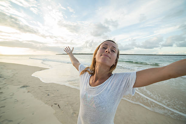istock Caucasian female relaxes on beach at sunset 589952682