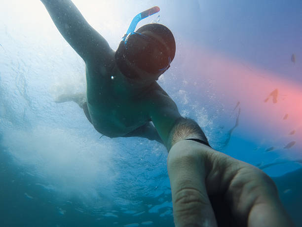 istock man diving deep in the sea and taking a selfie 589953800