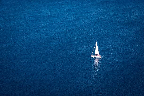big blue - solitude remote sailboat horizontal stock-fotos und bilder