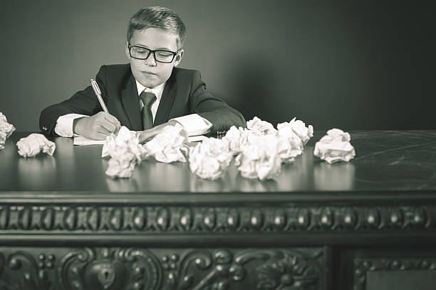 istock Inspired school boy writing essay or exam 589955702