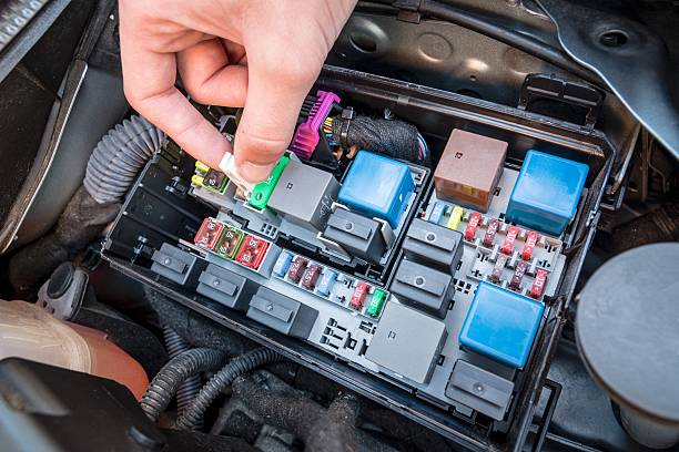 controllo a mano di un fusibile in un motore di un'auto - automotive fuses foto e immagini stock