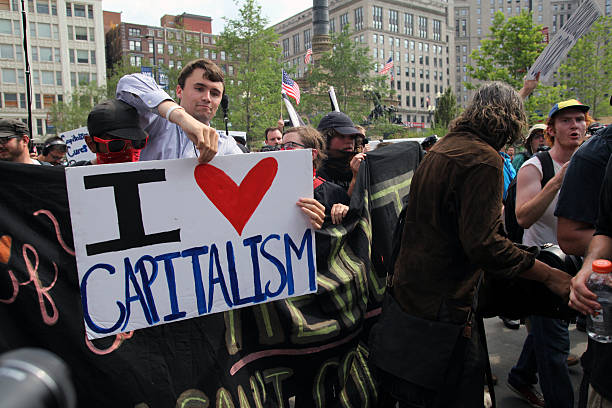 Cleveland, Ohio, USA - July 21, 2016: A young capitalist crashes a march by members of the IWW (Industrial Workers of the World), a labor union with roots in the socialist and anarchist labor movement, on the fourth and final afternoon of the Republican National Convention. There was an elevated level of tension on the convention's last afternoon and evening.