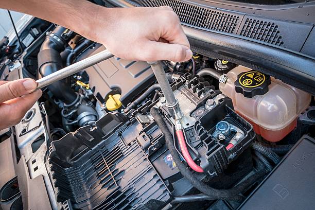 istock Hands checking a car battery bolt  with a wrench 589956856