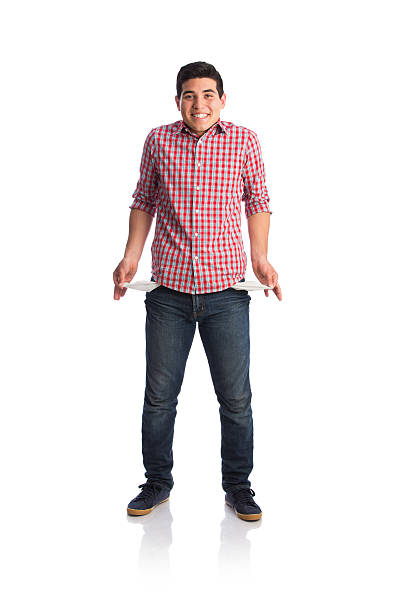 istock Young man showing empty pockets and smiling at camera 589957450