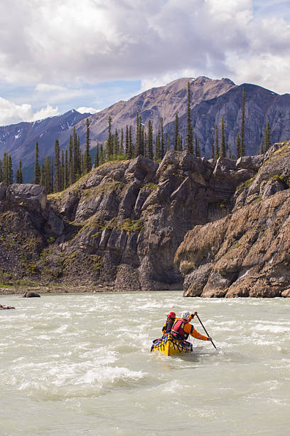 istock Two young people paddle a river in Northern Canada 589957458