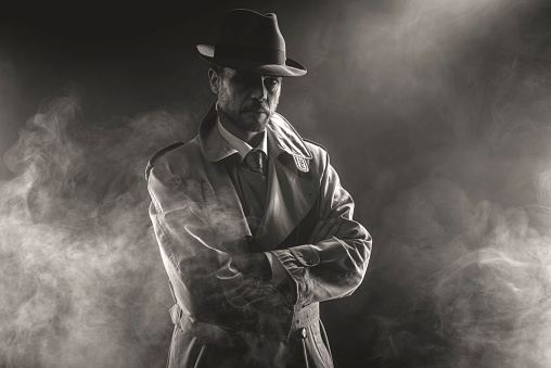Mysterious man waiting with arms crossed in the fog, 1950s style film noir