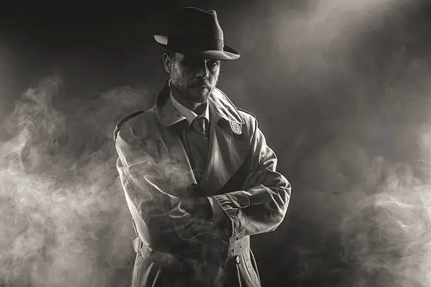 Mysterious man waiting with arms crossed in the fog, 1950s style film noir