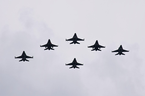 Six fighters flying on the cloudy sky.