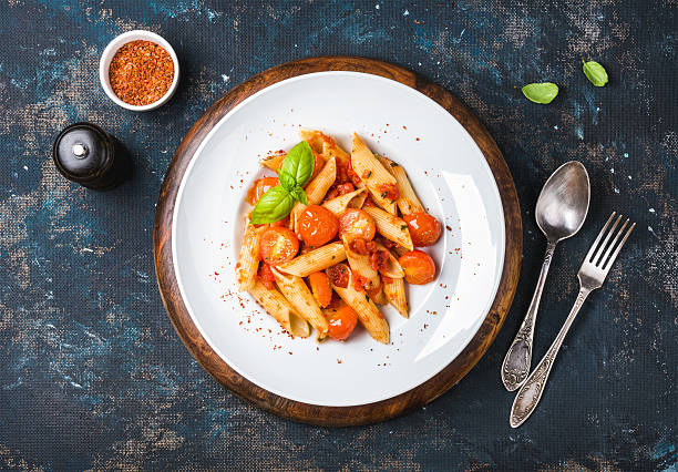 istock Pasta penne with tomato sauce, fresh basil and roasted tomatoes 589959426