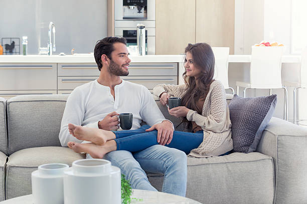 istock Couple drinking coffee on the sofa. 589959586