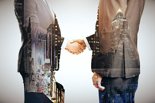 istock Businesspeople shaking hands multiexposure 589960640