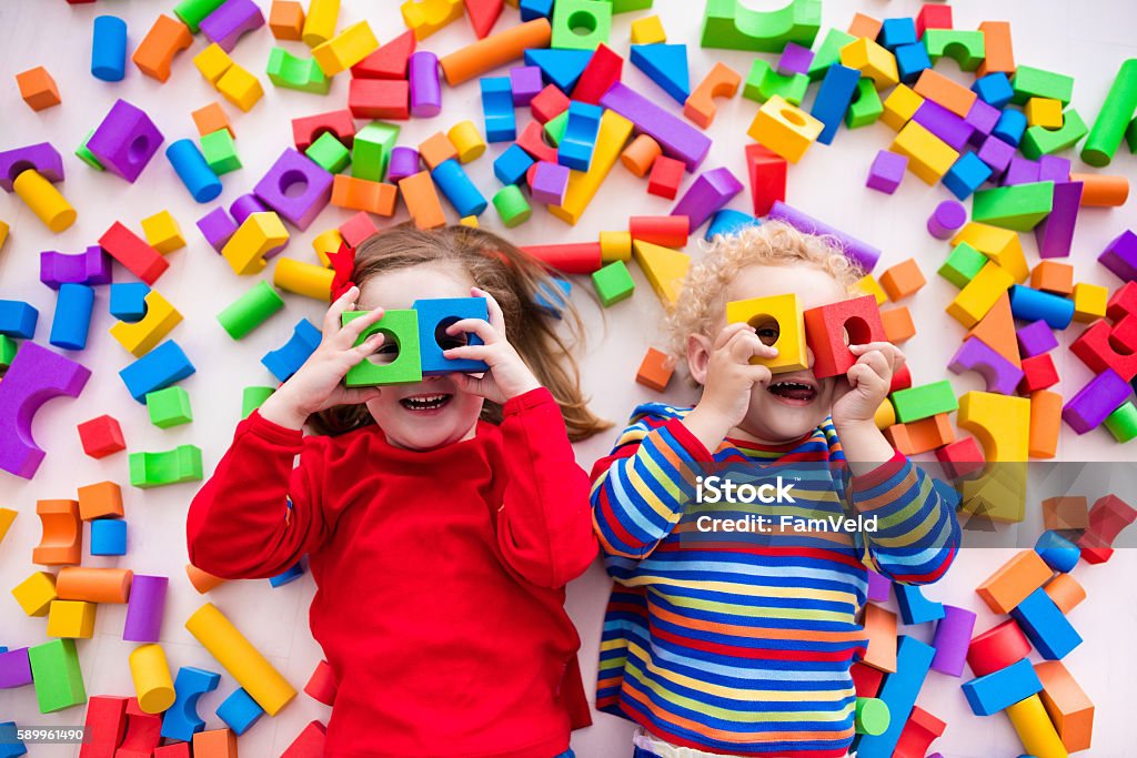 Kinder spielen mit bunten Blöcken und bauen einen Blockturm - Lizenzfrei Kind Stock-Foto
