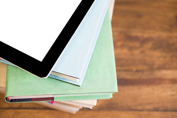 istock Textbooks, digital tablet stacked on wooden school desk. 589961578