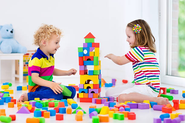 istock Kids twins playing with colorful toy blocks 589962144