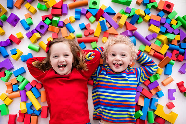 istock Funny children playing with colorful blocks. 589962316