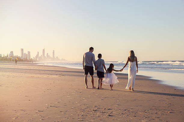 Family of four portrait on the beach, toning soft focus Family of four portrait on the beach, soft selective focus, toning queensland photos stock pictures, royalty-free photos & images