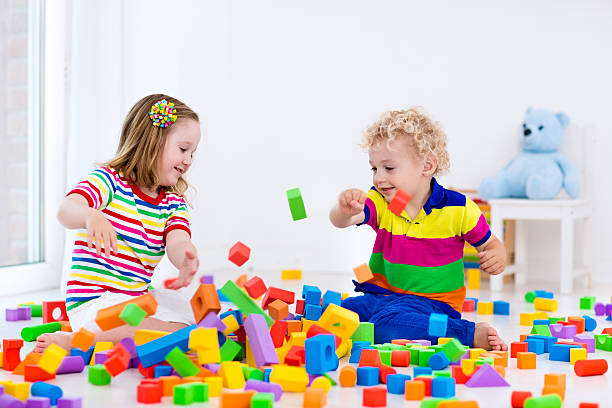 istock Adorable kids playing with colorful blocks. 589962788