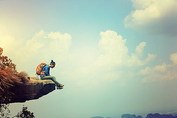istock successful woman hiker enjoy the view on mountain top cliff 589963792