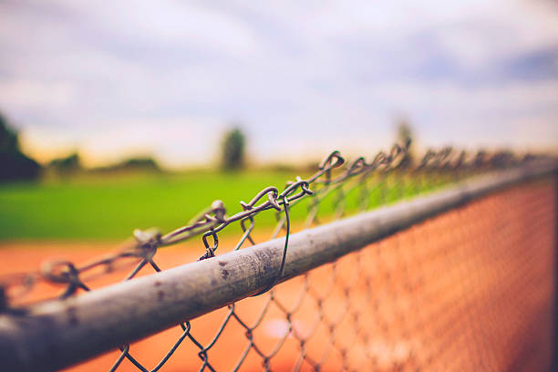 istock Chain link fence bordering defocused baseball field 589965682