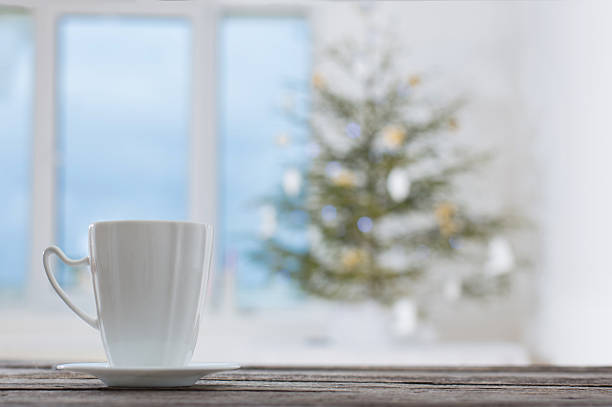 white cup on background Christmas fir and window