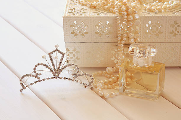 istock White pearls necklace, diamond tiara and perfume on toilette tab 589971144