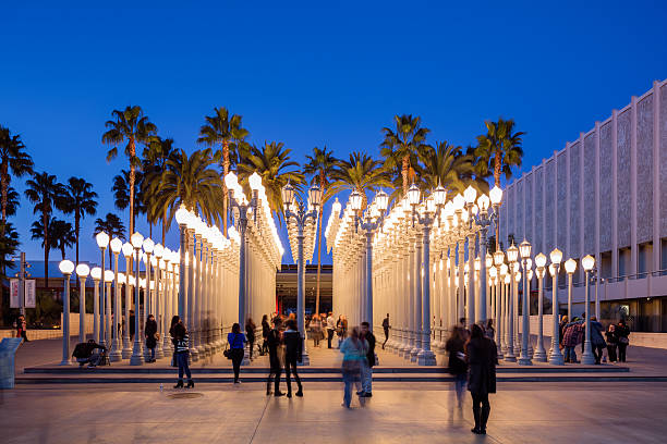 Urban Light by Chris Burden at LACMA Los Angeles, California, USA - July 7th, 2016: Visitors at one of LA's landmark the "Urban Light" by Chris Burden which is a well-known installation in at LACMA. The installation consists of 202 restored street lamps from the 1920s and 1930s. Most of them once lit the streets of Southern California. frank gehry building stock pictures, royalty-free photos & images