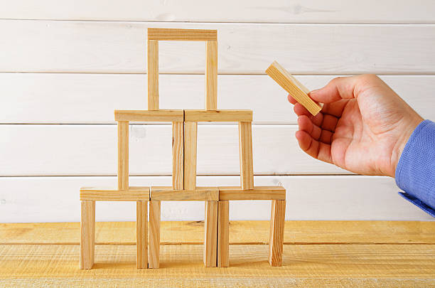 istock Male hand building a tower from domino bricks 589971344
