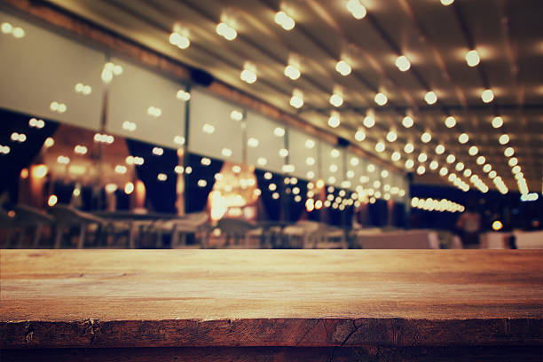 istock wooden table in front of abstract blurred restaurant lights 589972216