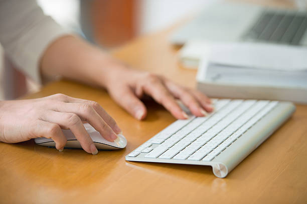 istock Close up of woman hands using mouse and keyboard. 589972904