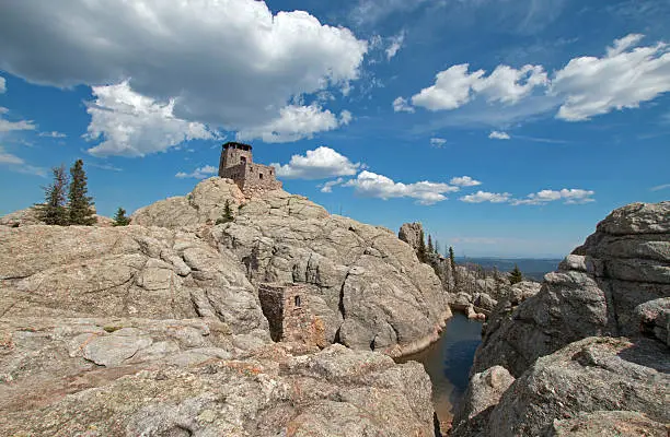 Harney Peak Fire Lookout Tower along with pumphouse below and small pond with dam in Custer State Parks Black Elk Wilderness in the Black Hills of South Dakota USA