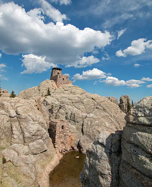 Harney Peak Fire Lookout Tower along with pumphouse below and small pond with dam in Custer State Parks Black Elk Wilderness in the Black Hills of South Dakota USA