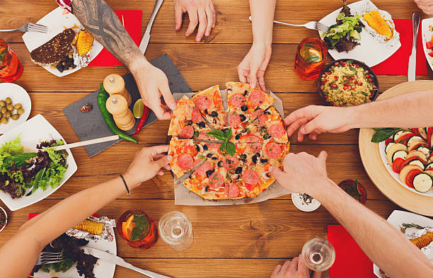 istock People eat pizza at festive table dinner party 589974494