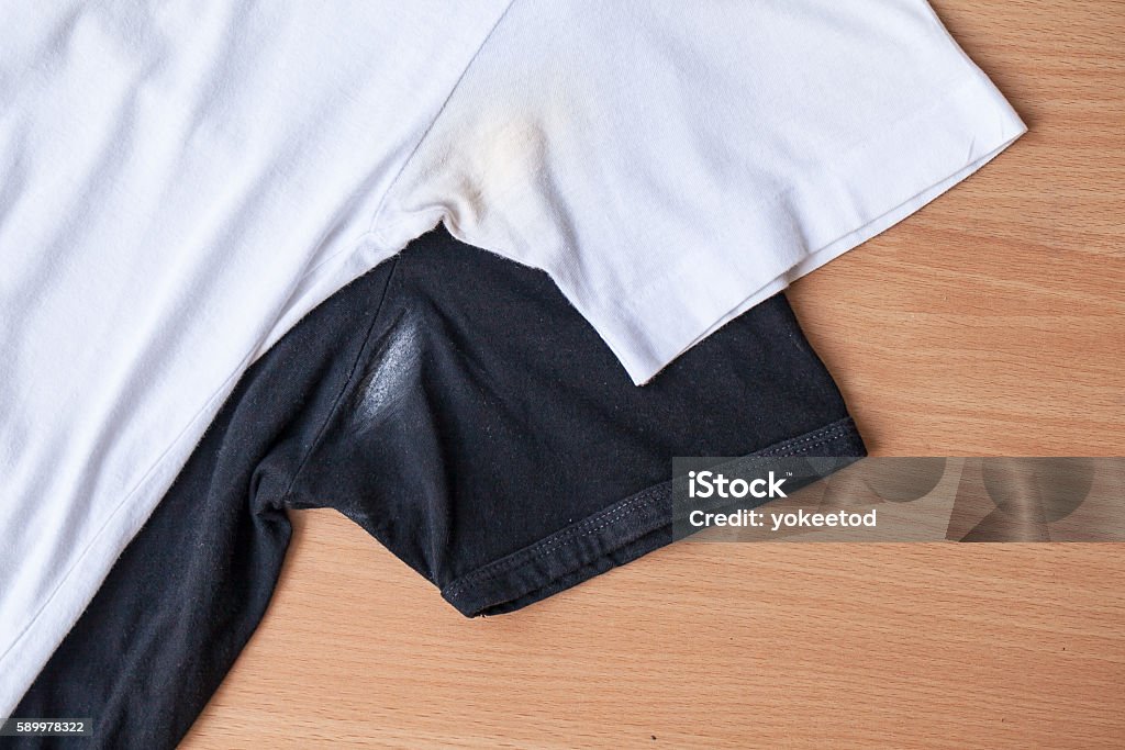 Shirts dirty caused by roll- on deodorant Shirts dirty caused by roll- on deodorant on wooden background Deodorant Stock Photo