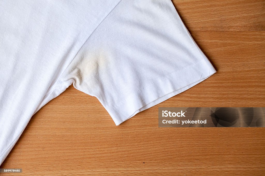 Shirts dirty caused by roll- on deodorant Shirts dirty caused by roll- on deodorant on wooden background Stained Stock Photo