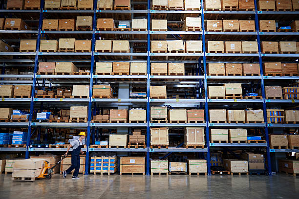 istock Coworker driving manuel forklift in warehouse aisle. 589980460
