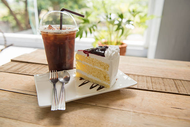 istock Ice coffee and blueberry cake on wood table,american Coffee, 589982160