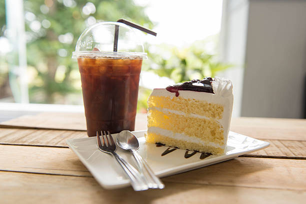 istock Ice coffee and blueberry cake on wood table,american Coffee, 589982202