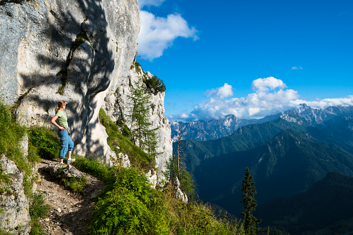 Dolomites mountains, Alpi Dolomiti beautiful scenic landscape in summer. Italian Alps mountain summits and rocky peaks above green valley alpine scene in autumn with clouds and yellow trees