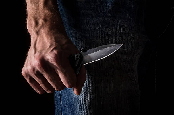 el hombre con un cuchillo en una mano. closeup. - cuchillo arma fotografías e imágenes de stock