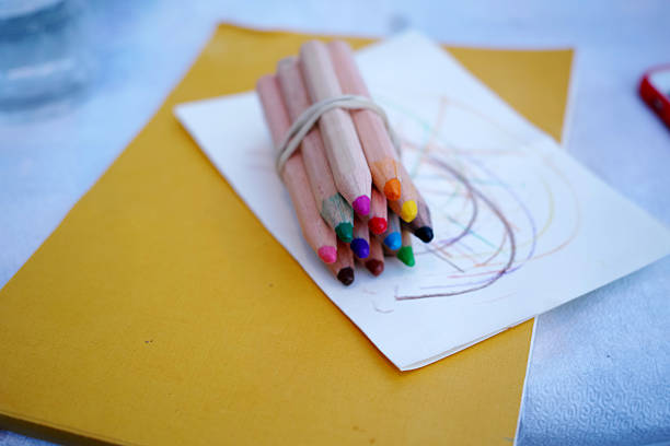 pencils are vibrant all together on the yellow paper - photograhy imagens e fotografias de stock