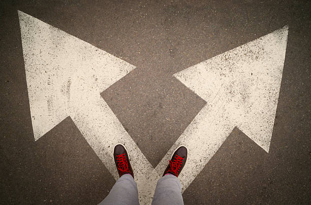 istock Shoes from above on the white arrows,dilemmas concept 589985696